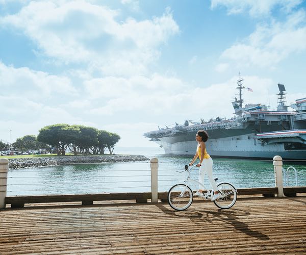 Young woman riding a bike along the San Diego Embarcadero