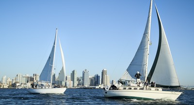 Two sailbots on San Diego bay with the skyline in the background