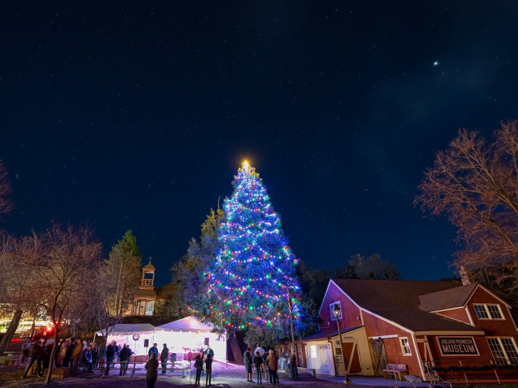 An illuminated Christmas tree rises over the town of Julian.