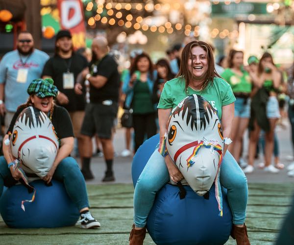 Two women riding bouncy unicorns at Shamrock in San Diego