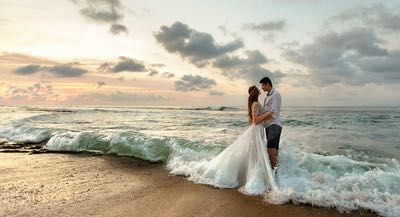Newledwed couple on the beach after their wedding ceremony