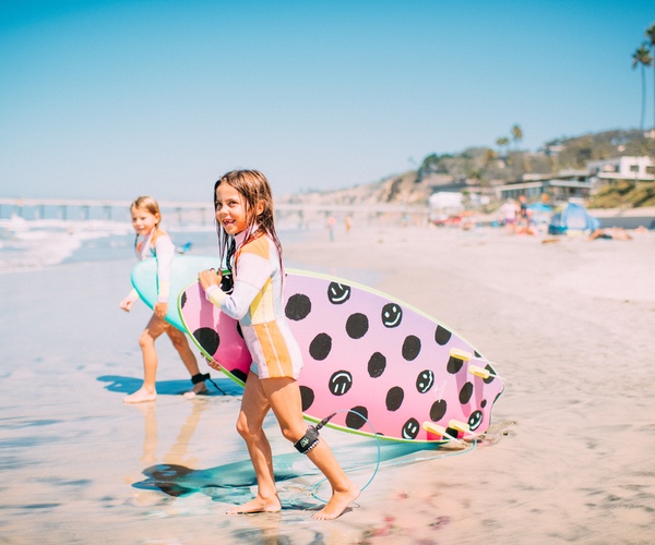 2 young girls with surfboard at La Jolla Shores in San Diego