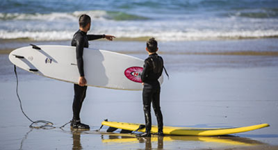 Dad and kid surfers at La Jolla Shores in San Diego CA