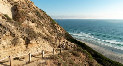 Hikers on a trail at Torrey Pines State Natural Reserve overlooking the Pacific Ocean