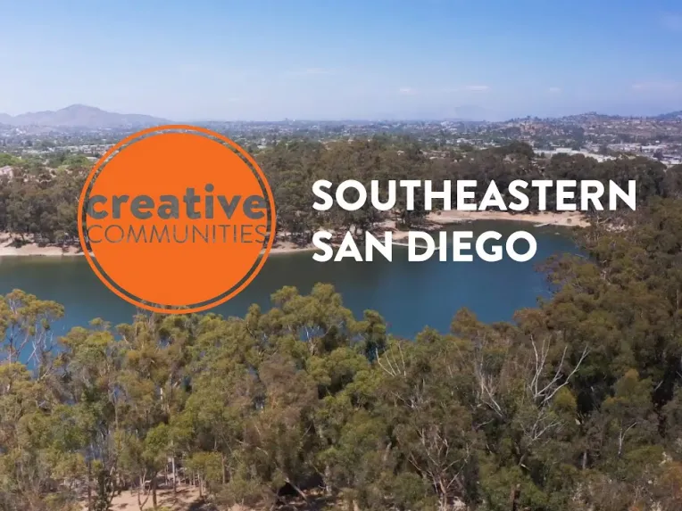 Aerial view of a lake surrounded by trees and hills, with the text "Creative Communities Southeastern San Diego" overlaid.