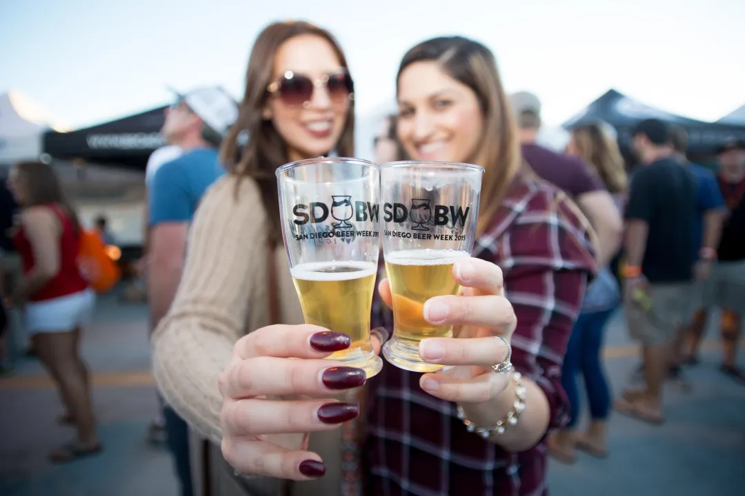 Two women cheersing their beers during San Diego Beer Week