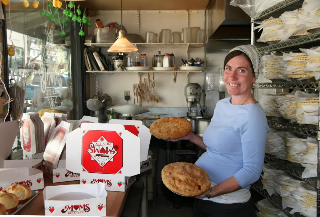 A baker holds pies amid stacked boxes inside Mom's Pie Shop in beautiful Julian, in the mountains near San Diego.