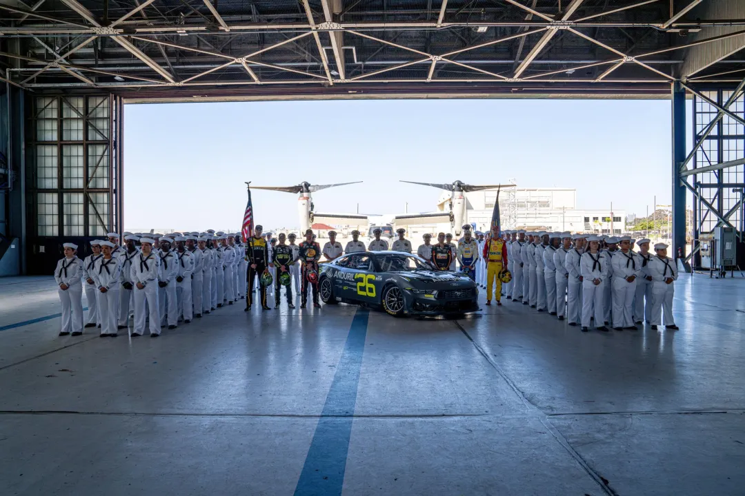 Service members surround a NASCAR race car in a hangar at Naval Base Coronado near San Diego.
