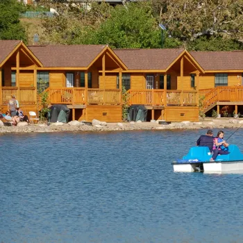 Lakefront cabins overlooking Santee lakes as a father daughter fish off of a pontoon boat