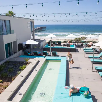 Couple enjoying the pool overlooking the Pacific Ocean at a hotel in San Diego