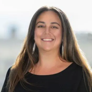 Jody Blackinton wearing a black top is smiling and looking at the camera, with a softly blurred background.