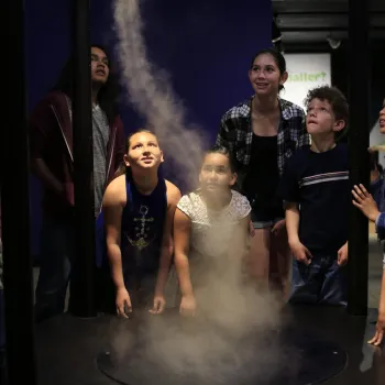 Kids surround a tornado exhibit at Fleet Science Center in San Diego's Balboa Park