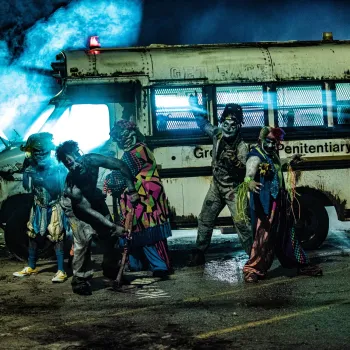 a group of people dresses as zombies and monsters in front of a haunted school bus in San Diego.