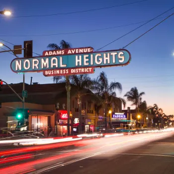 Normal Heights neighborhood sign over Adams Avenue during a sunset in San Diego