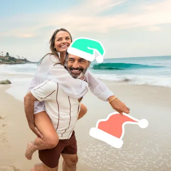 Couple on the beach in San Diego with Santa hat graphics added to their head