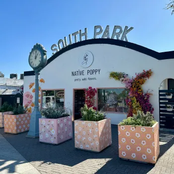 South Park neighborhood sign over Native Poppy store with a clock in this San Diego neighborhood 