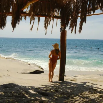 A woman leaning against a pole of the windansea shack in La Jolla San Diego