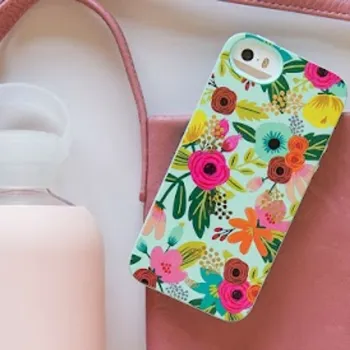 A floral phone case rests on a pink bag next to a frosted reusable water bottle with a white lid.