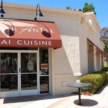 Exterior of a Thai restaurant with a brown awning labeled "Star Anise Thai Cuisine," glass doors, and outdoor tables along the sidewalk.