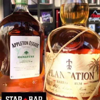 Two bottles of rum—Appleton Estate Signature from Jamaica and Plantation Barbados—are displayed side by side on a bar counter.