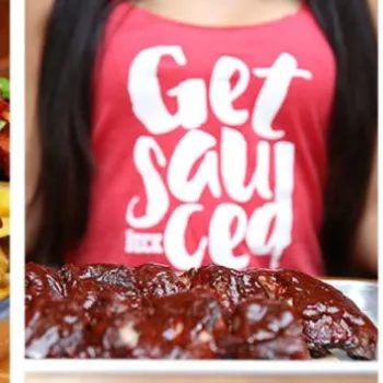 Tray of loaded fries with meat and green onions, plate of saucy ribs in front of a person wearing a "Get Sauced" shirt, and three glasses of beer on a wooden table.