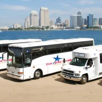 Four Five Star Tours vehicles—a van, a minibus, and two large buses—are parked near a waterfront with a city skyline in the background.