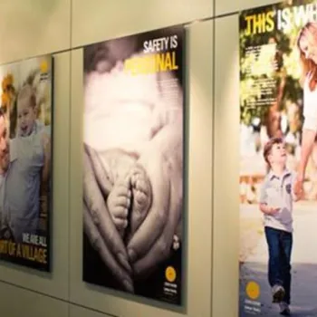 A row of posters on a wall, featuring images of families and safety-related messages.