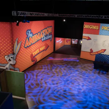 Exhibit space with colorful walls featuring Bugs Bunny and Marvin the Martian, labeled "The Animation Academy," and areas titled "Origins," "Process," and "Pencil Test.