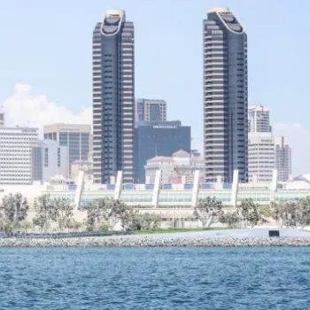 Skyline view of downtown San Diego with tall buildings, waterfront, and the San Diego Convention Center seen from across the bay.