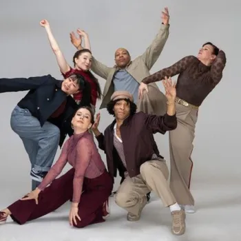 Six people pose together in expressive, dynamic stances against a plain light background, wearing casual and semi-formal clothing in various colors.
