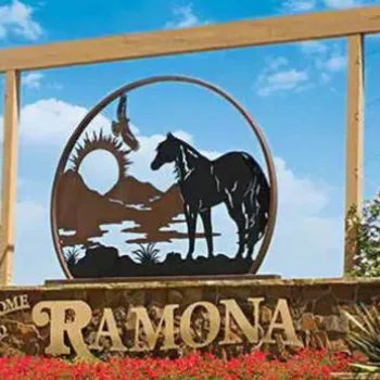 A large roadside sign reads "Welcome to Ramona" and features a metal silhouette of a horse, trees, and a sunset scene against a blue sky.