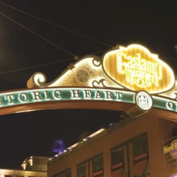 A metal arch sign reading "Historic Heart of San Diego" marks the entrance to the Gaslamp Quarter, with streetlights and buildings visible at night.