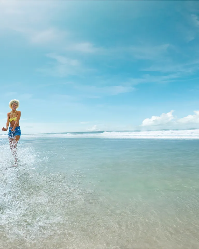 Mother and son splashing on the wide open sands of a San Diego beach on a sunny day
