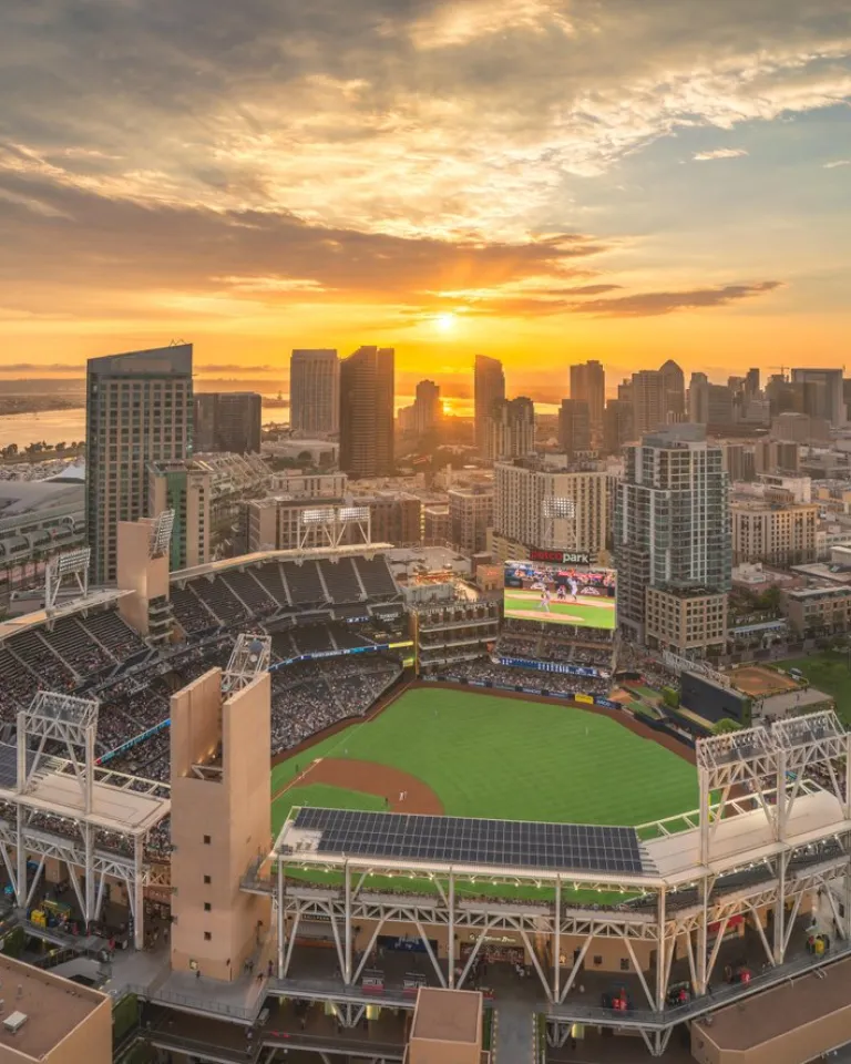 Aerial view of Petco Park stadium at sunset with Downtown San Diego behind it