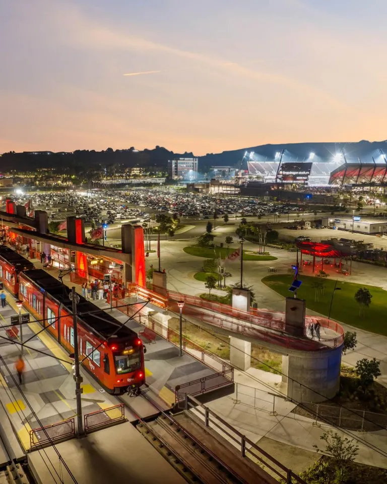 Trolley is stopped outside of Snapdragon Stadium at dusk in San Diego, CA