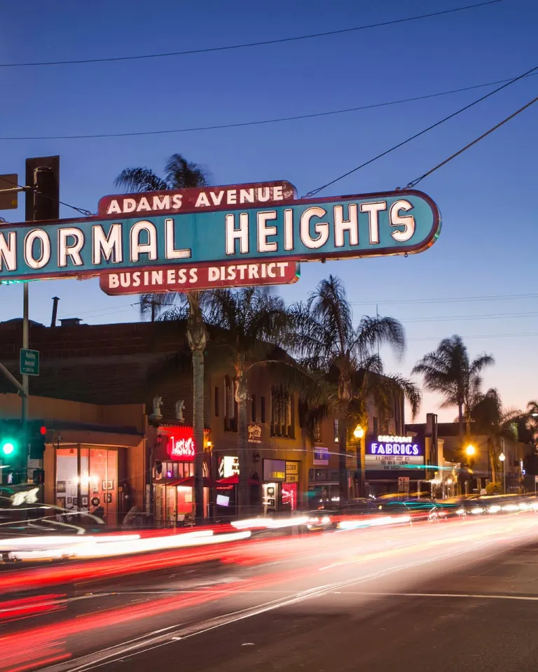 Normal Heights neighborhood sign over Adams Avenue during a sunset in San Diego