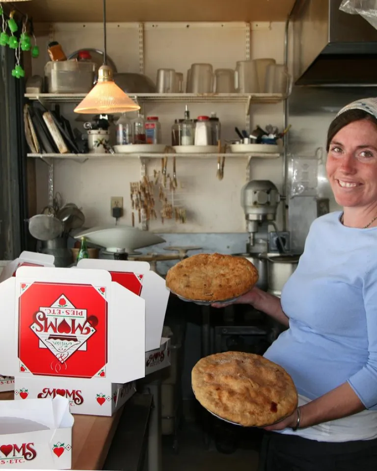 A baker holds pies amid stacked boxes inside Mom's Pie Shop in beautiful Julian, in the mountains near San Diego.