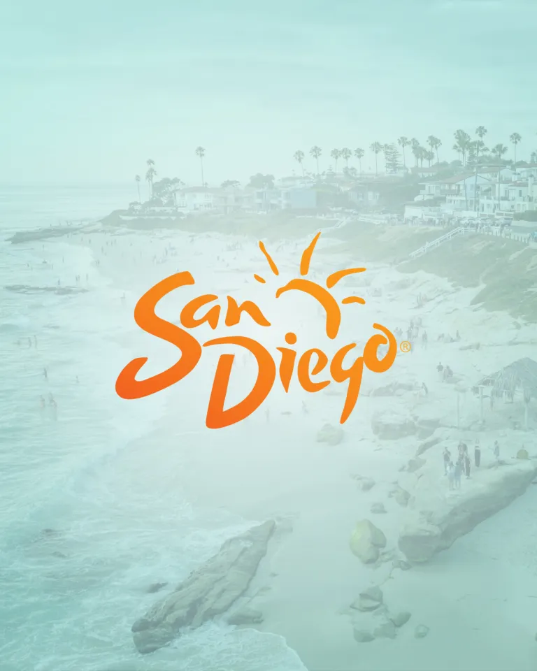 A coastal beach scene in San Diego with people on the sand and in the water, overlaid with an orange "San Diego" logo featuring a stylized sun.