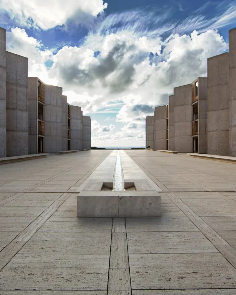A view of the Salk Institute in the La Jolla neighborhood of San Diego, with symmetrical buildings on each side stretching to a view of the ocean on the horizon.