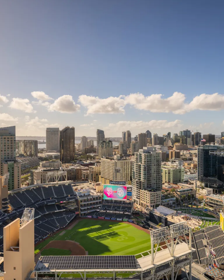 Panoramic view of the San Diego skyline with the San Diego Padres' Petco Park in the foreground under beautiful blue skies.