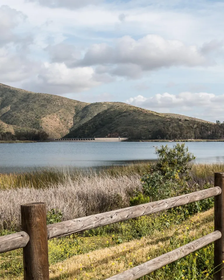 A view of Otay Lakes in Chula Vista near San Diego, bordered by hills and green vegetation.