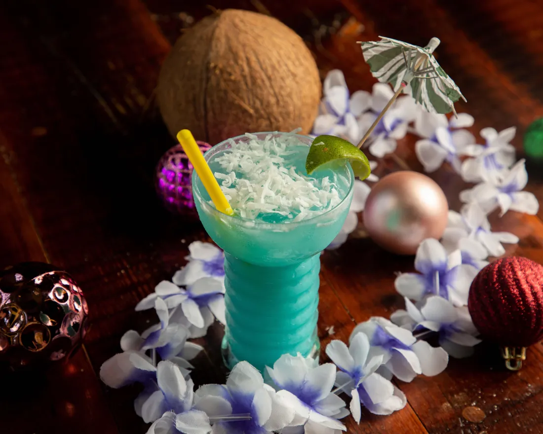a tiki drink on top of the table with a coconut 