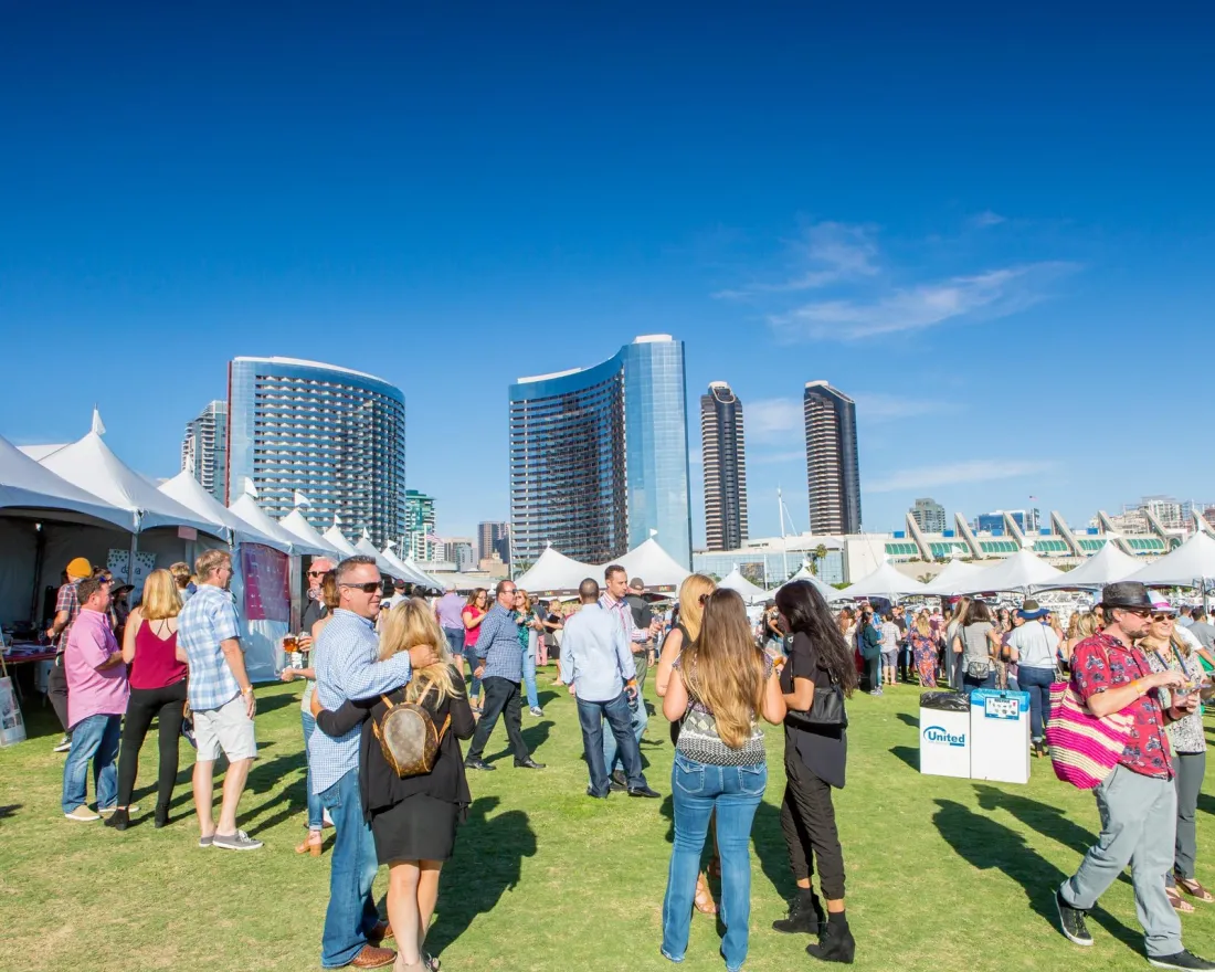 Two lines of tents at the San Diego Wine and Food Festival at Waterfront Park on a sunny cloudless day 