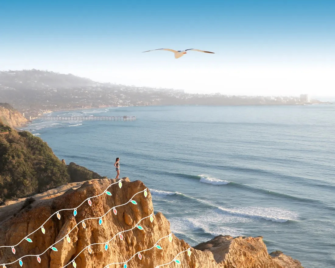 Female hiker standing atop a hill at Torrey Pines Regional State Park with some fun holiday graphics of lights superimposed