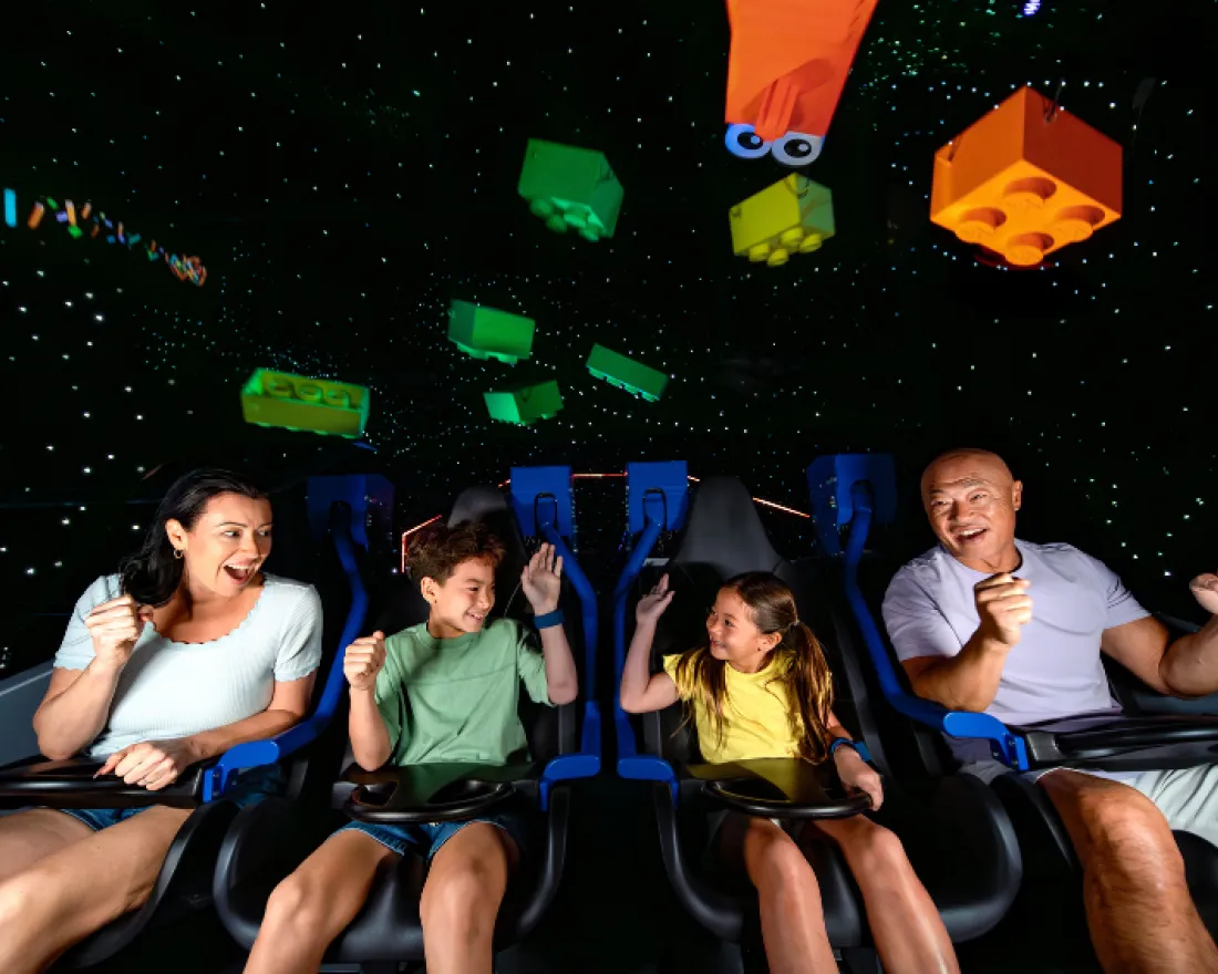 A family enjoys a vibrant virtual ride, smiling with excitement against a colorful backdrop.