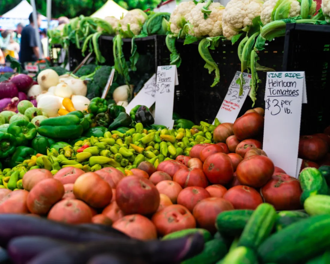 Colorful array of fresh vegetables and fruits at a market stall.