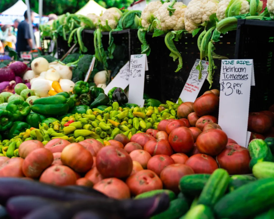 Colorful array of fresh vegetables and fruits at a market stall.