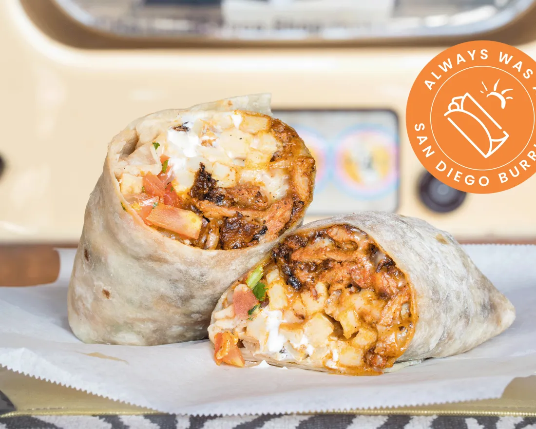 Close-up of two burritos filled with rice, beans, and toppings, against a soft background.
