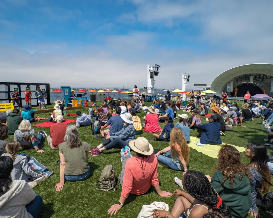 Free Event in San Diego at the Rady Shell a large group of people sitting on the lawn of the Rady Shell