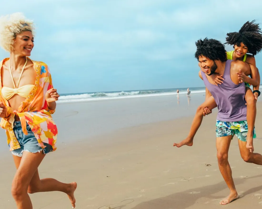 Kid gets piggy back ride from father while running on San Diego beach after mother